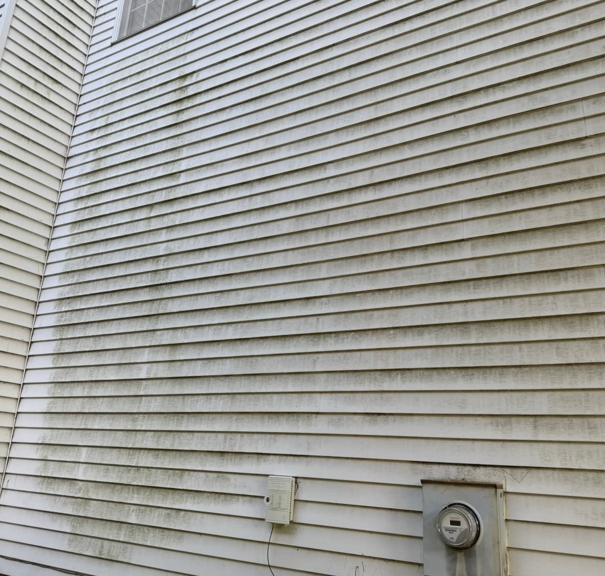 Dirty vinyl siding before cleaning in Quad Cities, IA